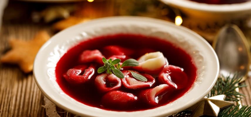 Clear ruby-colored barszcz czerwony (Polish beetroot soup) served with uszka dumplings, the traditional Wigilia starter.