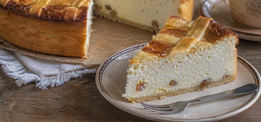 A slice of sernik, the Polish cheesecake made with twaróg farmer's cheese, served with black coffee in a traditional café setting.