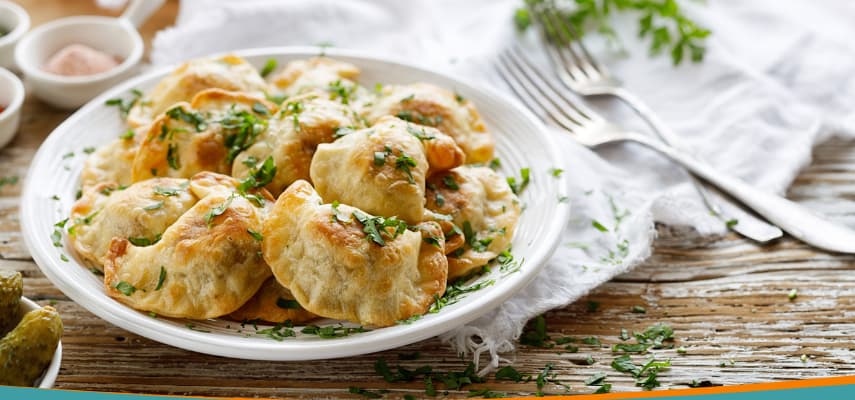 Pierogi, traditional Polish dumplings pan-fried with caramelised onion, served on a plate