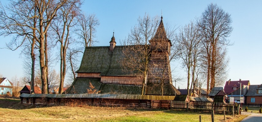 The shingled timber walls and steep roof of the 15th-century wooden church in Dębno.