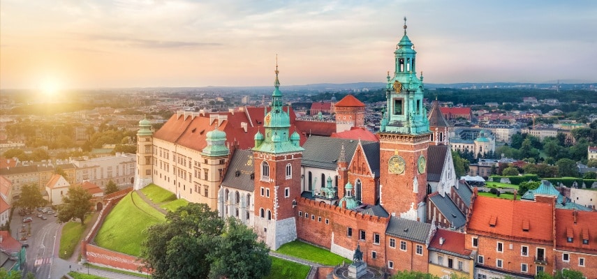 Kraków's Main Market Square surrounded by historic townhouses with the Cloth Hall in the center.